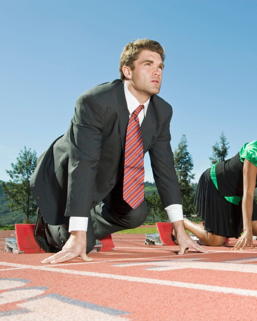 Man i kostym på startlinjen på en löparbana.